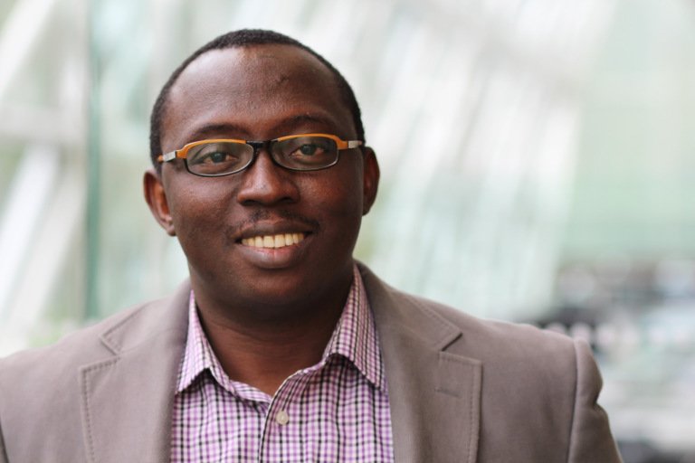 man with glasses smiling in a suit