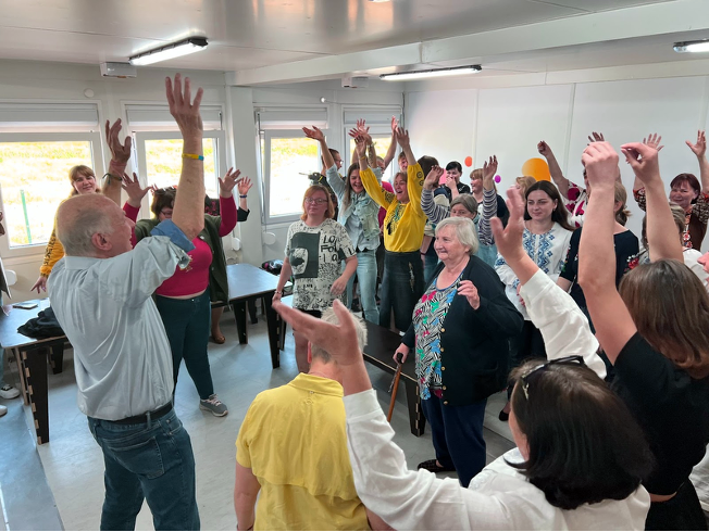 Jim and displaced people in Ukraine with hands lifted