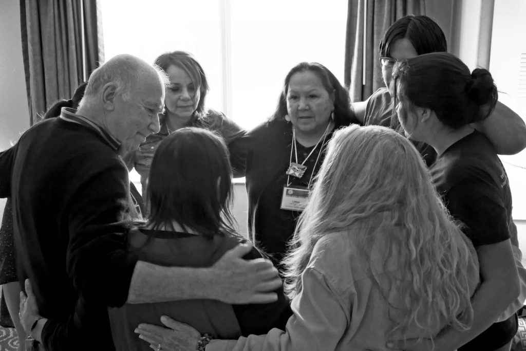 Jim and group with interlocked arms in a circle